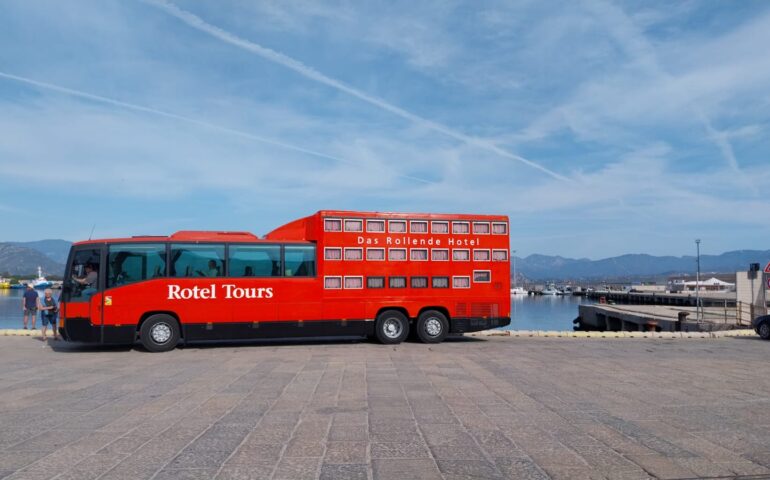 Arbatax, un autobus-hotel fa capolino nel porto, tra gli sguardi curiosi dei passanti